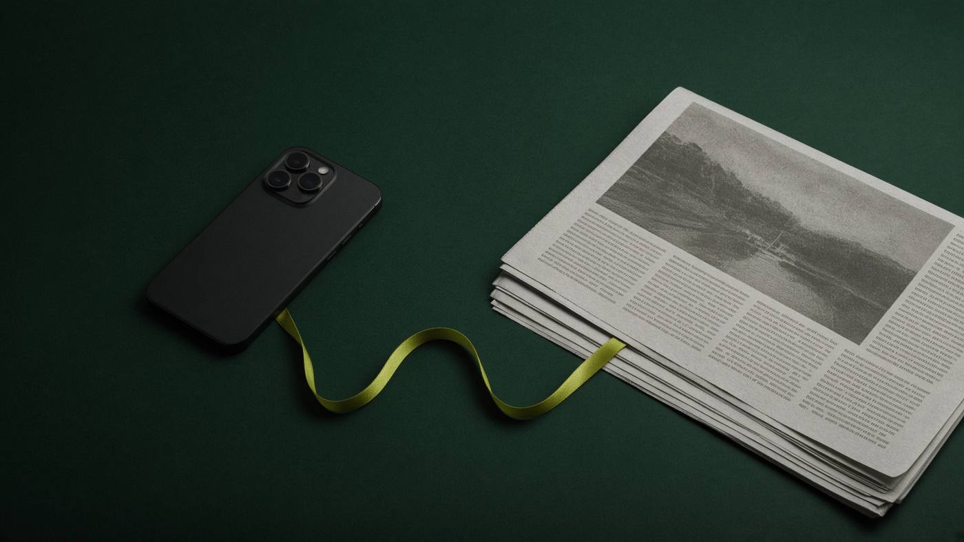 A phone and a newspaper joined by a ribbon, for social media marketing that supports search